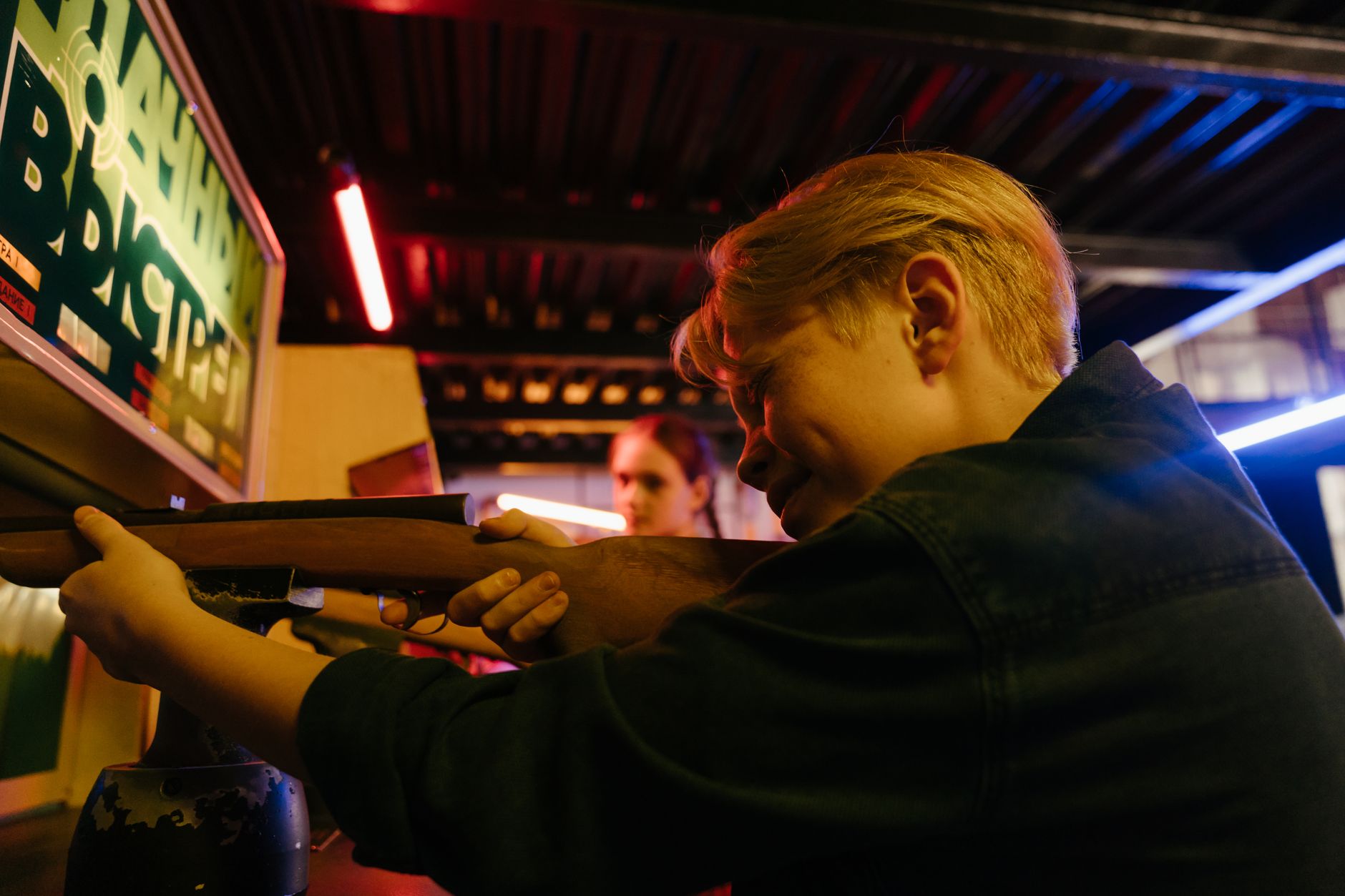 man in black jacket holding rifle